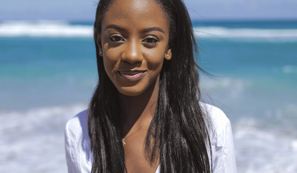 Cheerful black young woman at ocean