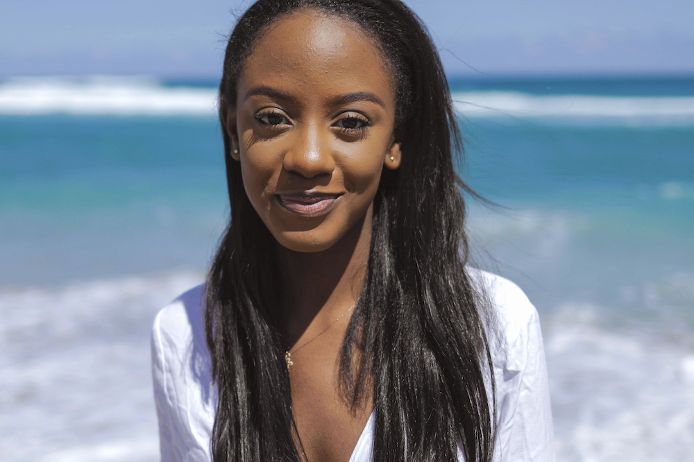 Cheerful black young woman at ocean