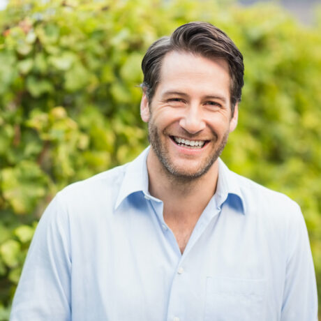Young happy man smiling at camera in the grape fields